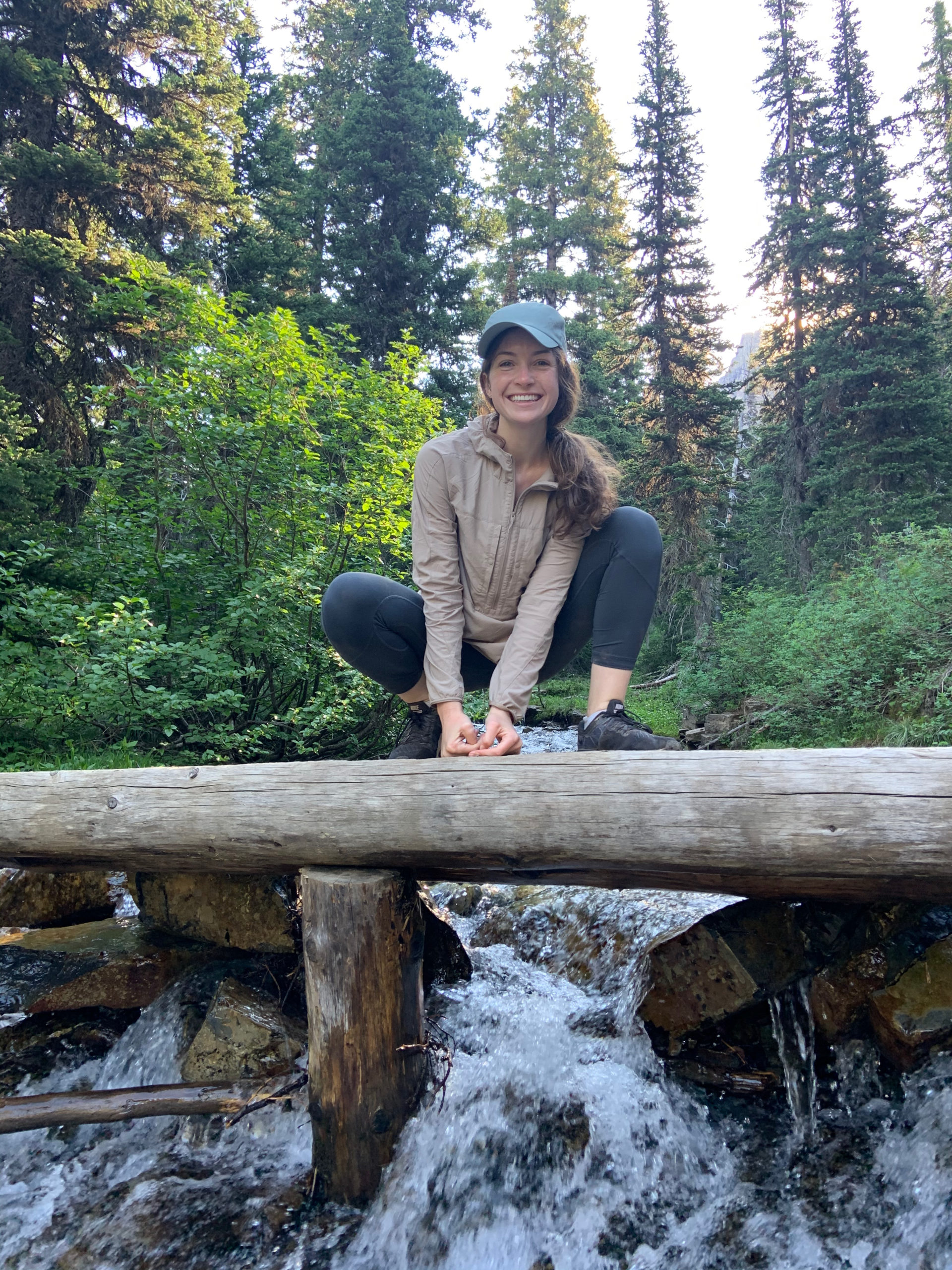 Rachel Downing balanced on log across waterfalls